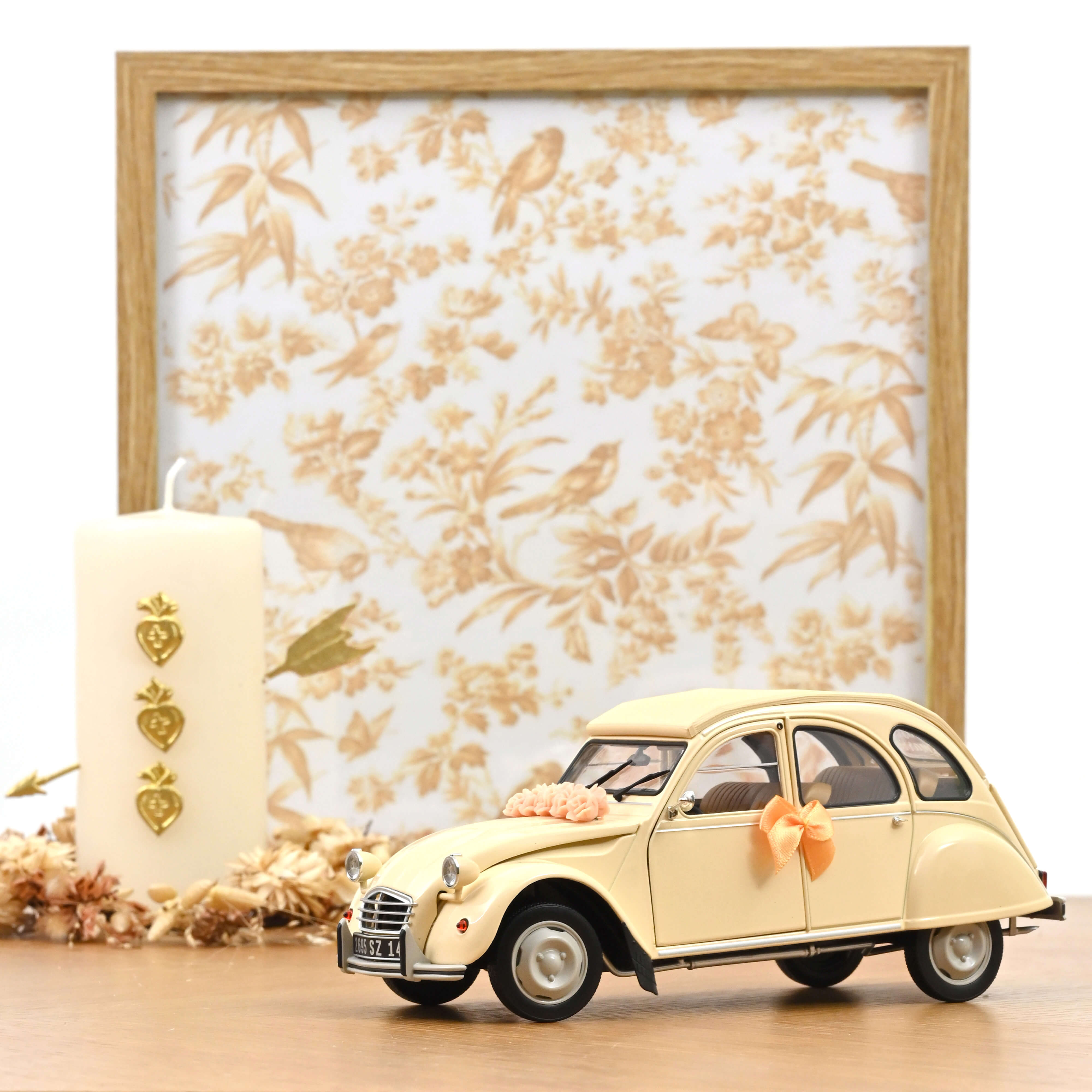 Voiture miniature Norev Citroën 2CV 1986 beige décorée pour un mariage avec fleurs et rubans sur fond floral