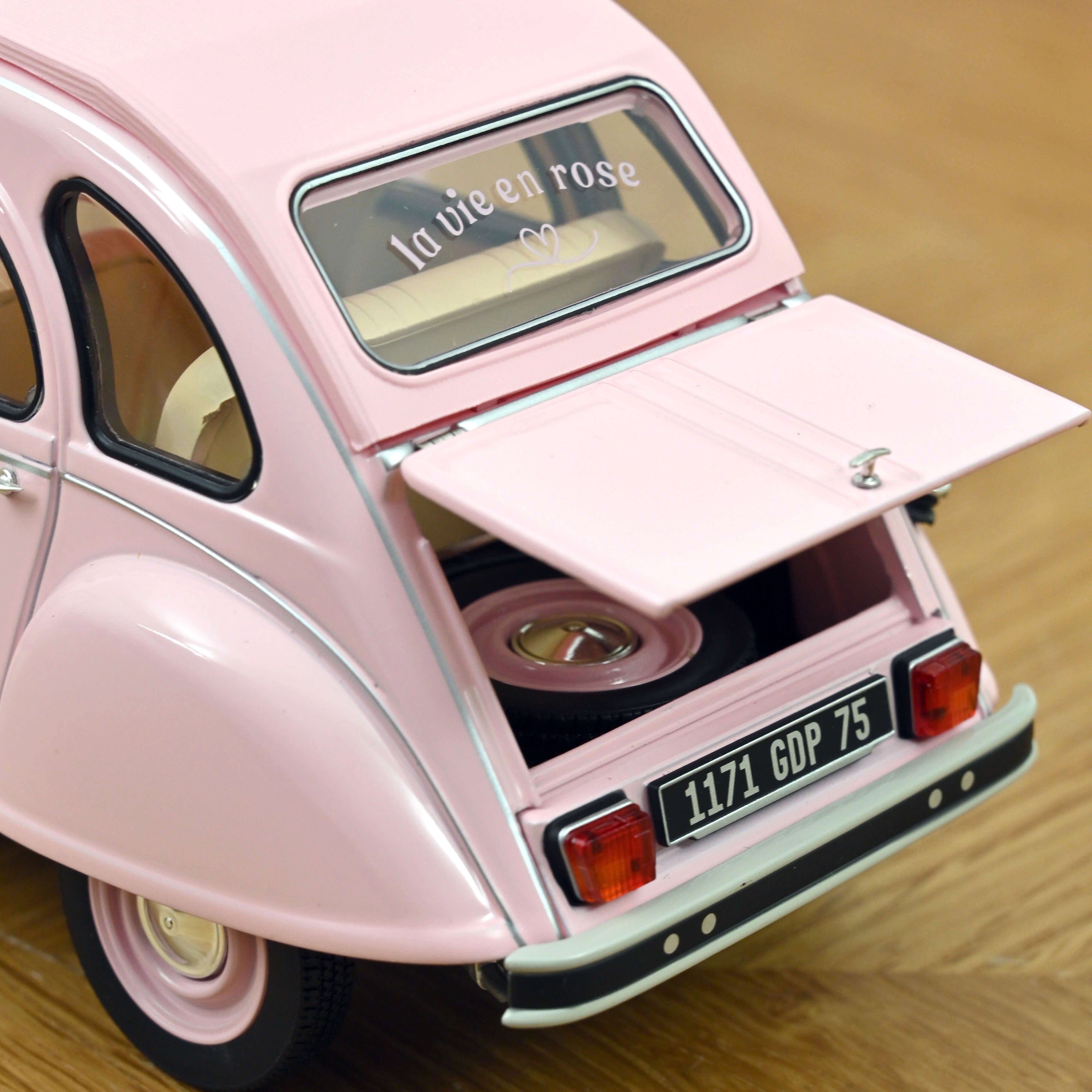 Vue arrière de la miniature Norev Citroën 2CV 1986 rose poudré avec inscription La vie en rose sur la lunette arrière